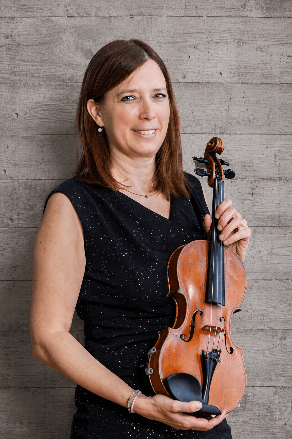 Portrait von Helen Steinemann mit Violine vor einer Betonwand